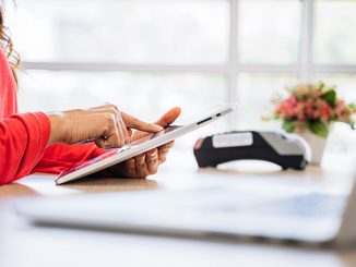 Verifactu-woman-using-tablet-device-at-desk-with-accessories-2026-03-18-13-50-19-utc